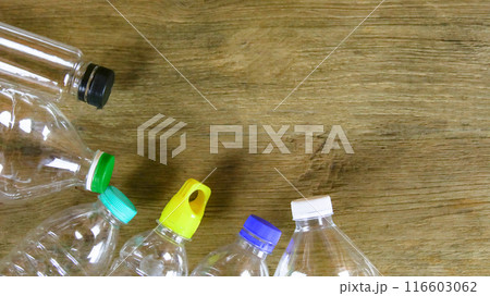 Waste plastic bottles on wooden background waiting for recycling concept of saving our environment sustainable natural resources. Waste plastic bottles on wooden background waiting for recycling concept of saving our environment sustainable natural resources. 116603062