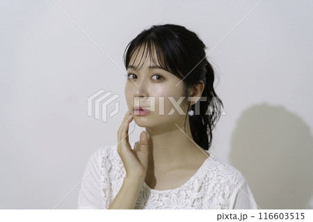 白背景の太陽の光を浴びる若い女性のポートレート 白背景の太陽の光を浴びる若い女性のポートレート 116603515