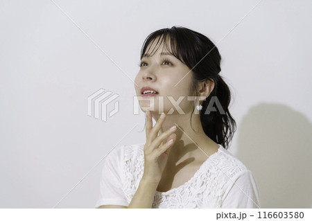 白背景の太陽の光を浴びる若い女性のポートレート 116603580