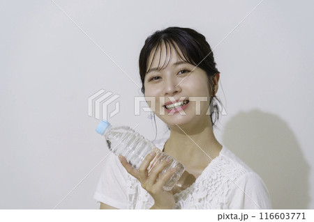 白背景のペットボトルの水を持つ若い女性のポートレート 116603771