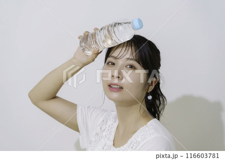 白背景のペットボトルの水を持つ若い女性のポートレート 116603781