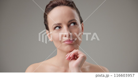 Concept of beauty, health, cosmetics, anti-aging therapy and skin care - young beautiful brunette Caucasian woman thoughtfully looks around making difficult choice thinking through actions 116603957