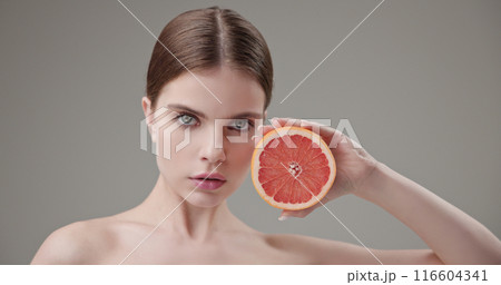 Beauty, health, cosmetics, anti-aging therapy and skin care concept - young beautiful brunette Caucasian woman holding half a grapefruit in her hands, concept of vitamins, freshness, fruit power Beauty, health, cosmetics, anti-aging therapy and skin care concept - young beautiful brunette Caucasian woman holding half a grapefruit in her hands, concept of vitamins, freshness, fruit power 116604341