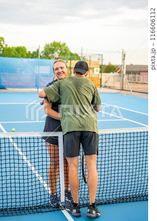 Professional tennis players shaking hands at the end of a tennis game on outside court Professional tennis players shaking hands at the end of a tennis game on outside court 116606112