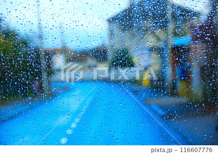 Rain outside window on city background. Water drops on glass during raining Rain outside window on city background. Water drops on glass during raining 116607776