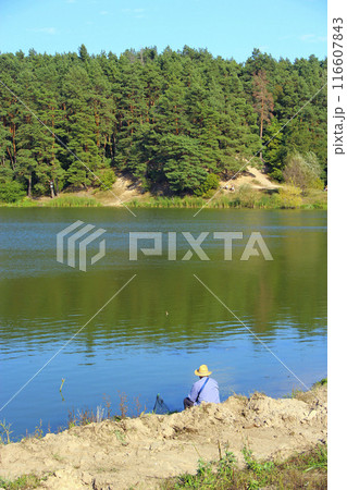 Fisherman standing on riverside and trying to catch fish. Male hobby. Recreation Fisherman standing on riverside and trying to catch fish. Male hobby. Recreation 116607843