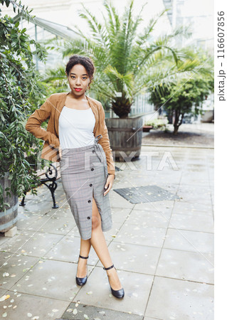 Stylish Young Woman in Modern Outfit Posing in an Urban Botanical Garden 116607856