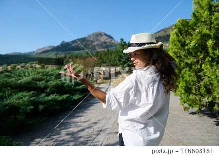 Woman in white shirt and hat exploring nature on a sunny day Woman in white shirt and hat exploring nature on a sunny day 116608181
