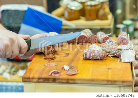 unrecognizable female hands cut a piece of salami unrecognizable female hands cut a piece of salami 116608748