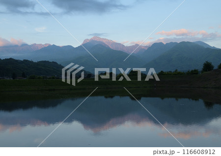 朝日が山頂に当たり明け行く南アルプス甲斐駒ケ岳。それを映す水田 朝日が山頂に当たり明け行く南アルプス甲斐駒ケ岳。それを映す水田 116608912