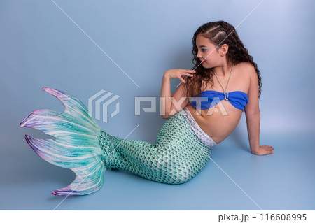 Beautiful elegant girl in a mermaid costume, isolated on a blue background. 116608995
