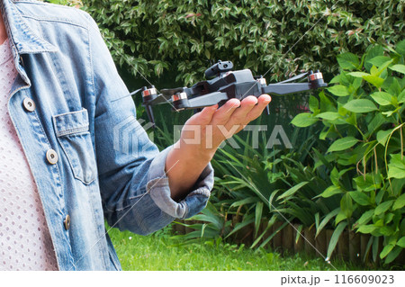Close up of caucasian woman hand holding a small drone outdoors Close up of caucasian woman hand holding a small drone outdoors 116609023