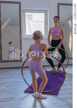 Gymnast child performs an exercise with hoop.Children's professional sports. Gymnast child performs an exercise with hoop.Children's professional sports. 116611189