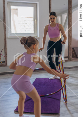 Gymnast child performs an exercise with hoop.Children's professional sports. Gymnast child performs an exercise with hoop.Children's professional sports. 116611190