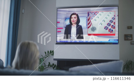 Adult woman watches TV news about elections in USA 116611346