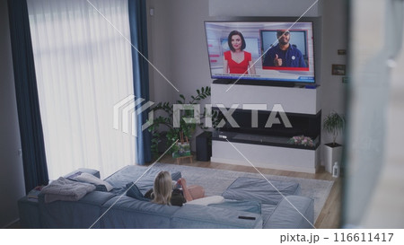 Young girl comes into room and sits on sofa near mother Young girl comes into room and sits on sofa near mother 116611417