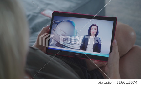 Tablet screen shows news broadcast about US elections with female newscaster 116611674