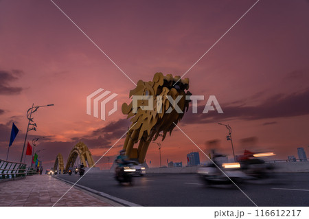 ベトナムダナン名物の夕方のドラゴンブリッジを走るオートバイや自動車 ベトナムダナン名物の夕方のドラゴンブリッジを走るオートバイや自動車 116612217