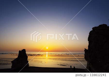 早春の北海道　滝瀬海岸の夕日と記念撮影するカップル 116612241