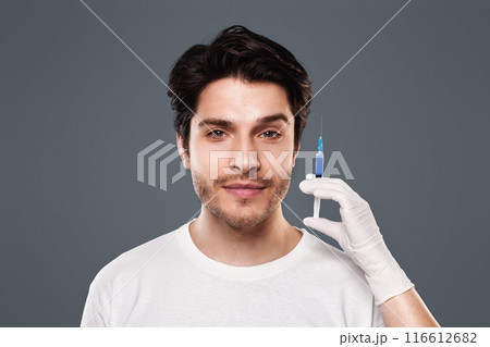 Beautician hands holding syringe with transparent liquid near male face, aesthetic cosmetology and beauty care 116612682