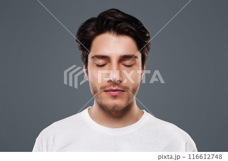 Portrait of handsome millennial man with closed eyes, grey studio background Portrait of handsome millennial man with closed eyes, grey studio background 116612748