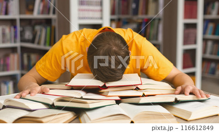 Student studying hard exam and sleeping on books in library, free space Student studying hard exam and sleeping on books in library, free space 116612849