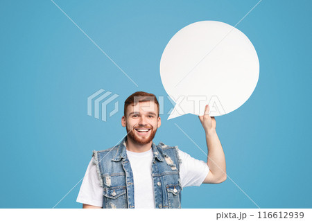 Millennial guy having idea. Smiling young man holding blank speech bubble and looking at camera on blue background, mockup, copy space Millennial guy having idea. Smiling young man holding blank speech bubble and looking at camera on blue background, mockup, copy space 116612939