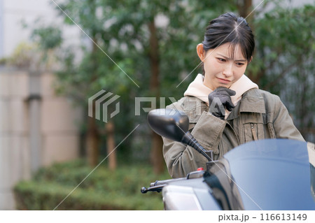 困った表情をする女性バイカー 116613149