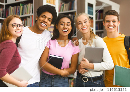 Group of international students studying in library at university, laughing together 116613321