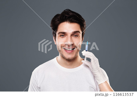 Trendy cosmetics procedure for men. Young man getting beauty injection, grey studio background 116613537