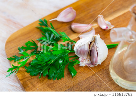 Garlic with parsley and olive oil on table Garlic with parsley and olive oil on table 116613762