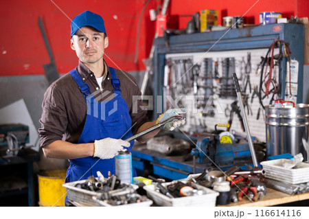 Portrait of professional auto mechanic in uniform with tools in his hands in car service center Portrait of professional auto mechanic in uniform with tools in his hands in car service center 116614116