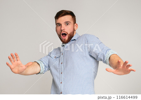 I am afraid. Portrait of scared man with open mouth and outstretched hands on studio background, copy space I am afraid. Portrait of scared man with open mouth and outstretched hands on studio background, copy space 116614499