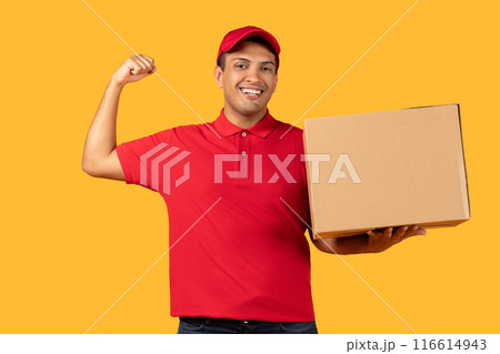 A cheerful delivery worker man in a red cap and polo shirt holds a cardboard box while flexing his arm, showing enthusiasm and strength. A cheerful delivery worker man in a red cap and polo shirt holds a cardboard box while flexing his arm, showing enthusiasm and strength. 116614943