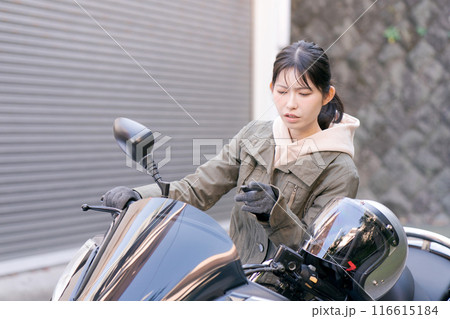 バイクに乗って悩む女性 116615184