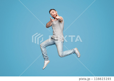 Gotcha. Emotional millennial redhaired guy pointing fingers at camera, full length, blue studio background, copy space Gotcha. Emotional millennial redhaired guy pointing fingers at camera, full length, blue studio background, copy space 116615193