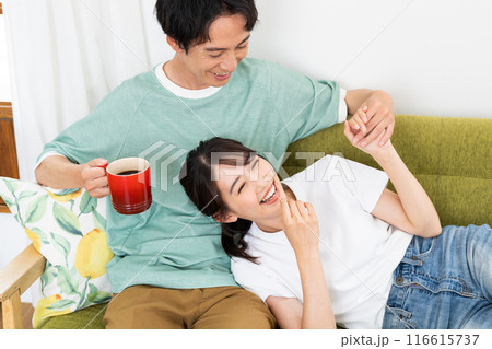 リビングでくつろぐ若い夫婦 リビングでくつろぐ若い夫婦 116615737