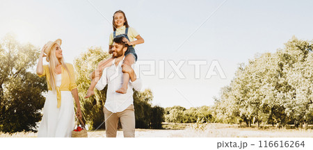 After-Quarantine Walk. Happy Family Walking In Countryside Spending Summer Day Outside Near River, Father Carrying Little Daughter. Full-Length 116616264