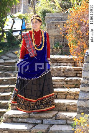 a villager girl dressing in Gurung traditional dressing walk down the staircase and look at camera a villager girl dressing in Gurung traditional dressing walk down the staircase and look at camera 116616919