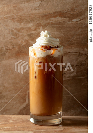 Iced caramel latte topped with whipped cream and caramel sauce. Iced caramel latte topped with whipped cream and caramel sauce. 116617928