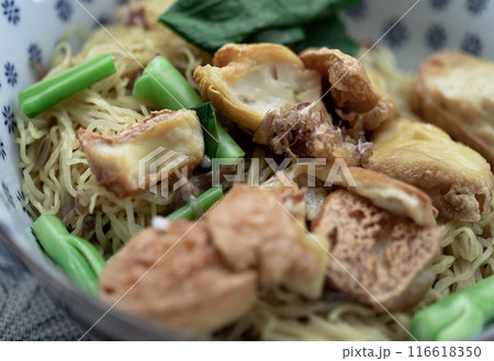 Close-up of Egg Noodles with Fried tofu and Chinese kale without Soup sprinkled with Fried garlic. 116618350
