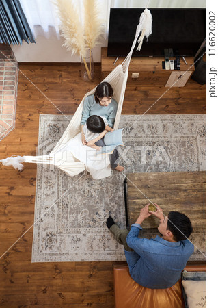 ハンモックのあるリビングで団欒する家族 116620002