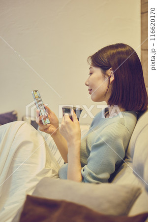 ソファーでスマホを使う女性 ソファーでスマホを使う女性 116620170