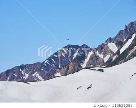 初夏の観光名所立山黒部アルペンルートの室堂山頂の雄大な風景と物質を輸送するヘリコプターの様子 116621089