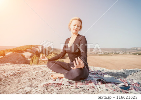 Woman Meditating on Mountaintop with Breathtaking View 116621625