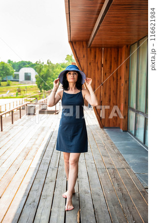 50 years old russian woman in short dress holding her hat on the sumer day 50 years old russian woman in short dress holding her hat on the sumer day 116621984