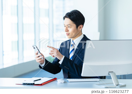 オフィスでスマホを持つビジネスマン オフィスでスマホを持つビジネスマン 116623277