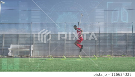 Image of interface processing data over male footballer training on pitch jumping hurdles Image of interface processing data over male footballer training on pitch jumping hurdles 116624325