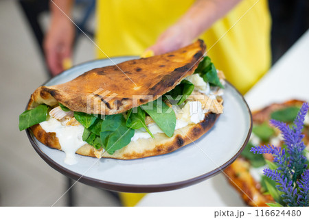 Opened opne calzone italian pizza with cheese in plate homemade in Lithuania 116624480