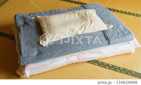畳の上に畳んだ布団と枕・和室と布団 116626806